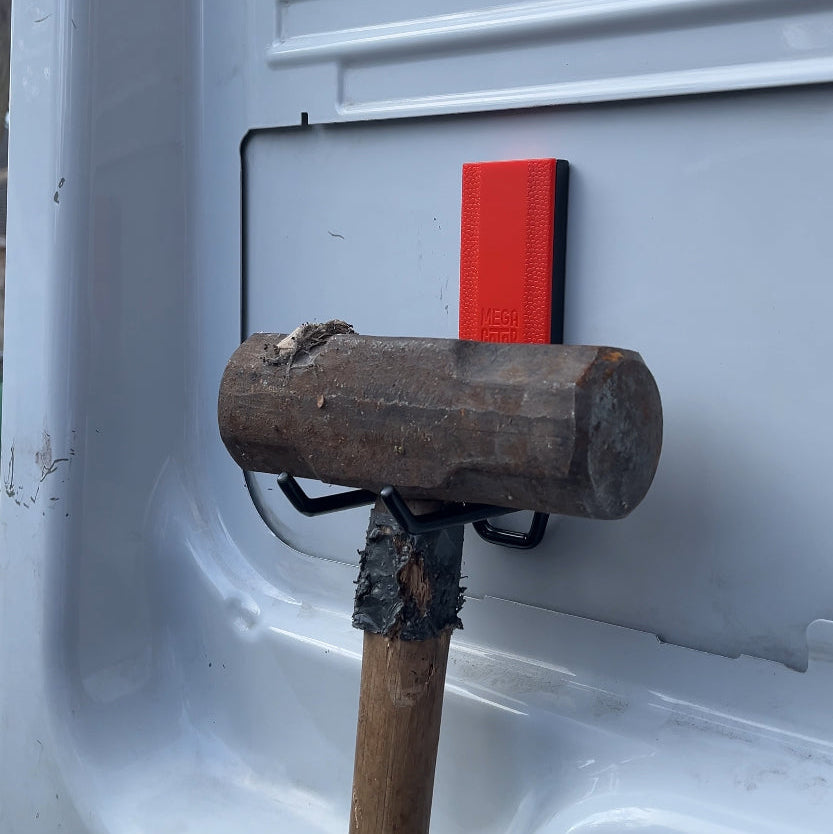 A Gator Magnetics hook holds a large sledgehammer on a smooth, flat,  steel van interior panel, demonstrating heavy-duty tool storage and microfiber towel storage potential in a compact work vehicle.